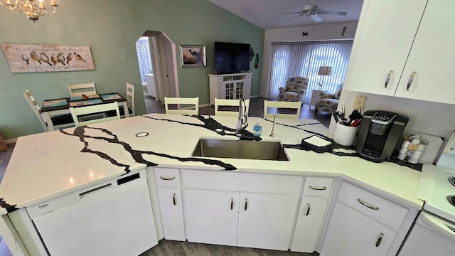 kitchen with white cabinetry, dishwasher, vaulted ceiling, and sink