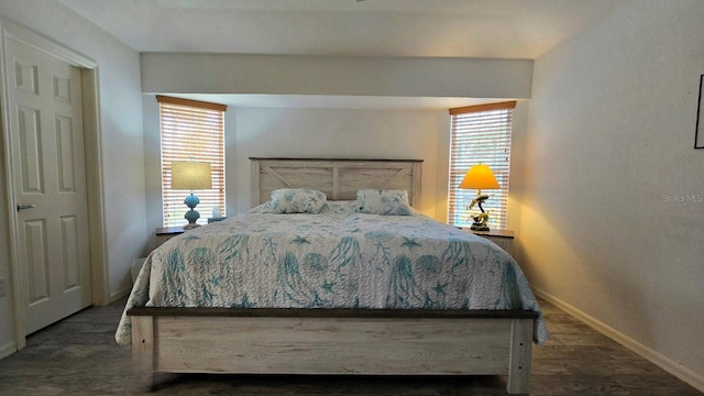 bedroom with dark hardwood / wood-style flooring and multiple windows