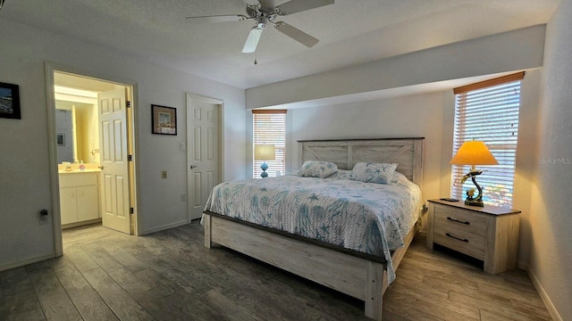 bedroom featuring dark hardwood / wood-style flooring, ensuite bathroom, and ceiling fan