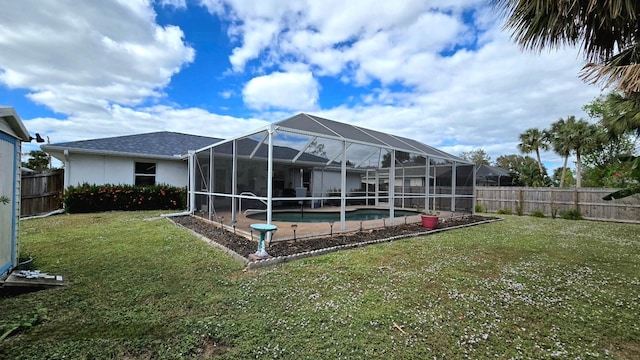 back of property with a lanai, a lawn, and a fenced in pool