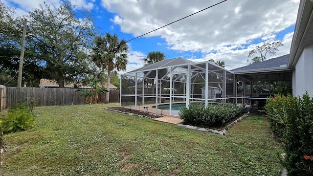 view of yard featuring a fenced in pool and glass enclosure