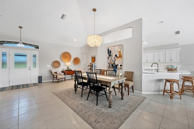 dining space featuring sink, light tile patterned floors, a chandelier, and lofted ceiling