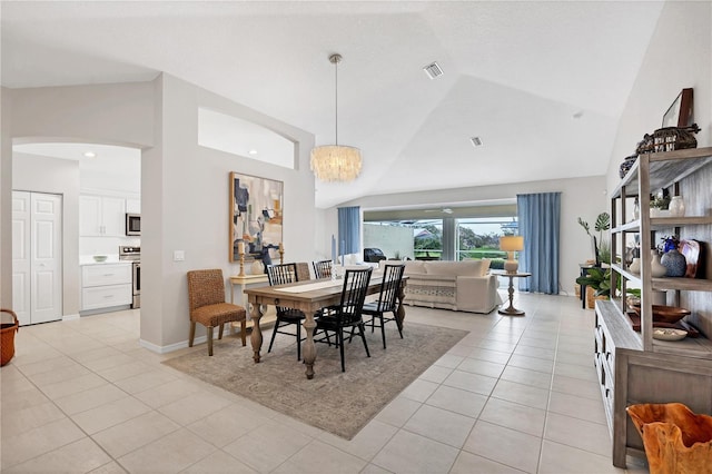 dining area featuring lofted ceiling, light tile patterned floors, and an inviting chandelier