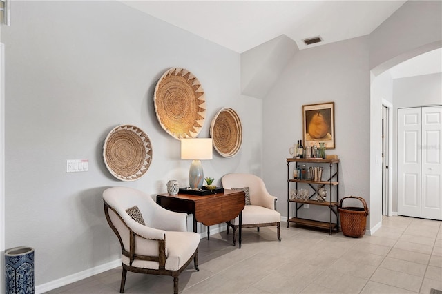 sitting room featuring light tile patterned floors and vaulted ceiling