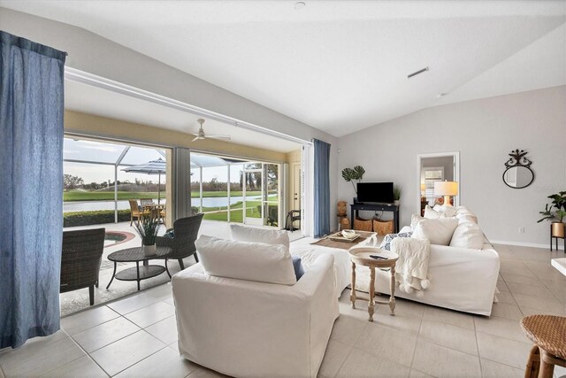 tiled living room featuring ceiling fan and vaulted ceiling