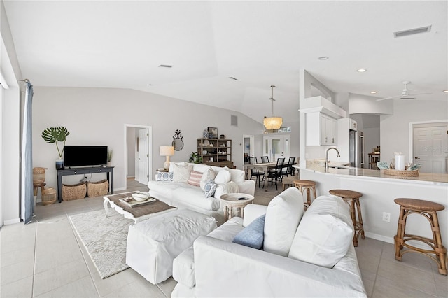 tiled living room with ceiling fan, lofted ceiling, and sink