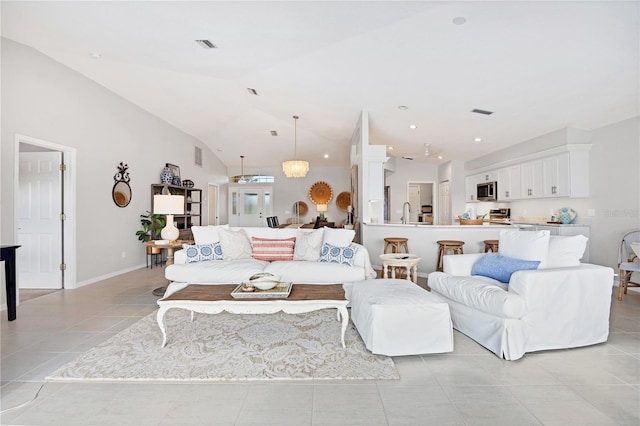 living room featuring light tile patterned floors, a chandelier, and vaulted ceiling