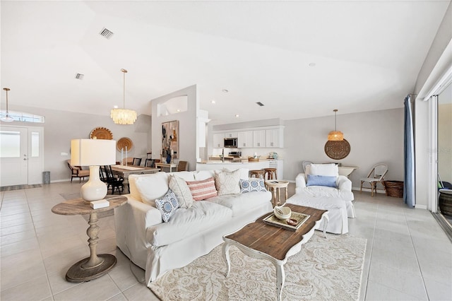 tiled living room featuring a chandelier and vaulted ceiling