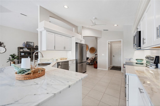 kitchen featuring stainless steel appliances, white cabinetry, lofted ceiling, and sink