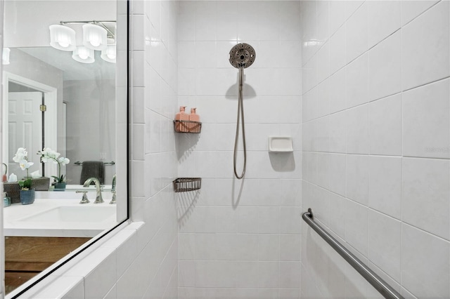 bathroom with a tile shower and vanity