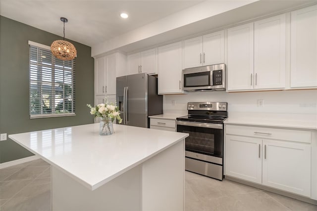 kitchen featuring stainless steel appliances, light tile patterned floors, white cabinets, a kitchen island, and hanging light fixtures