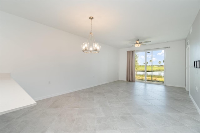 spare room with ceiling fan with notable chandelier, light tile patterned flooring, and a water view