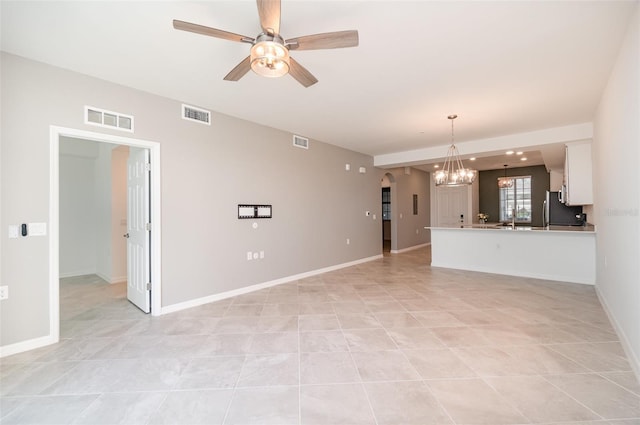 unfurnished living room featuring ceiling fan with notable chandelier and light tile patterned floors