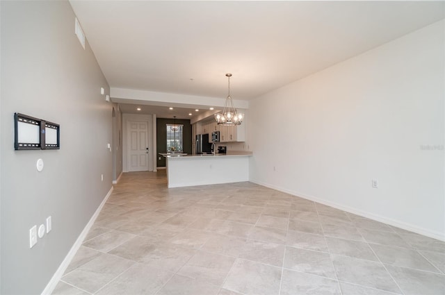 interior space featuring kitchen peninsula, white cabinets, a chandelier, stainless steel refrigerator, and hanging light fixtures