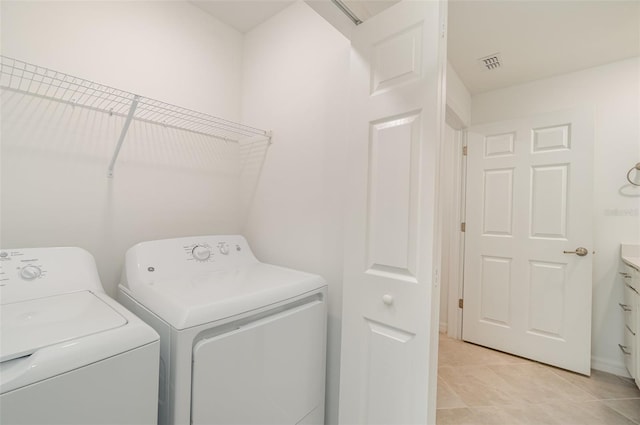 clothes washing area with light tile patterned floors and separate washer and dryer