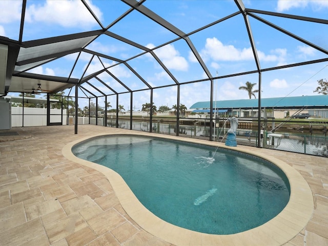 view of swimming pool with a lanai, pool water feature, a water view, and a patio