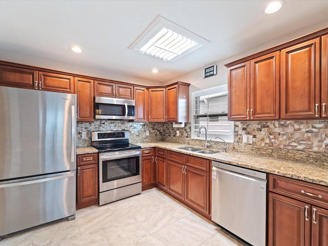 kitchen with tasteful backsplash, light stone countertops, sink, and appliances with stainless steel finishes