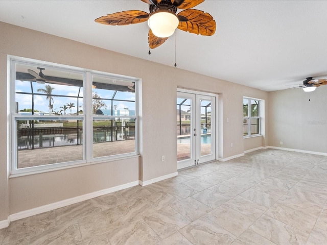 empty room with ceiling fan and a water view