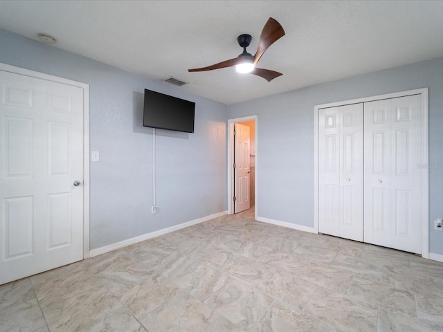 unfurnished bedroom featuring ceiling fan and a closet