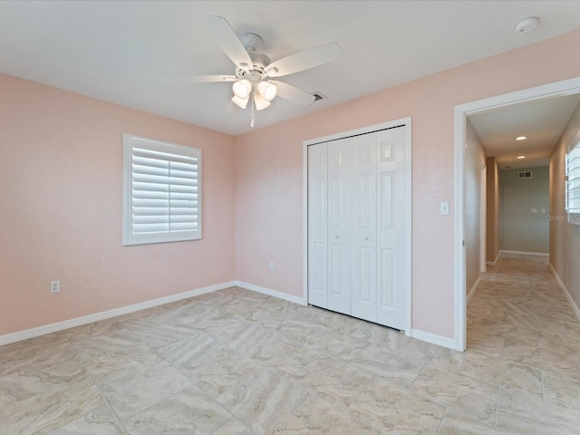 unfurnished bedroom with ceiling fan and a closet