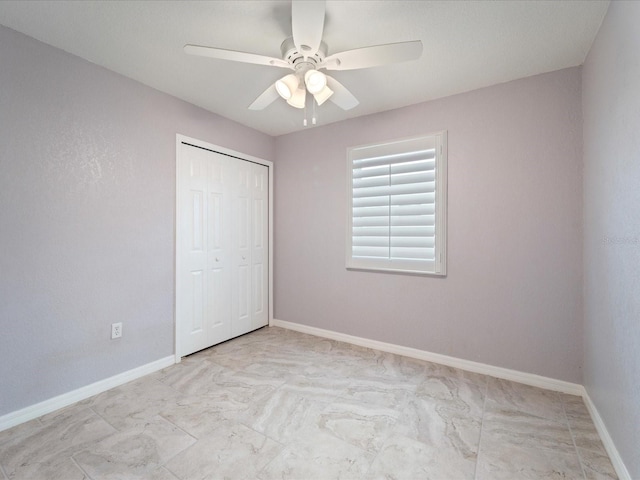 unfurnished bedroom with ceiling fan and a closet