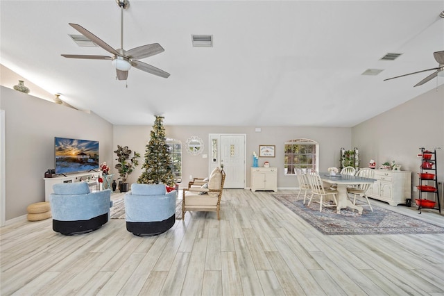 living room with lofted ceiling, ceiling fan, and light wood-type flooring