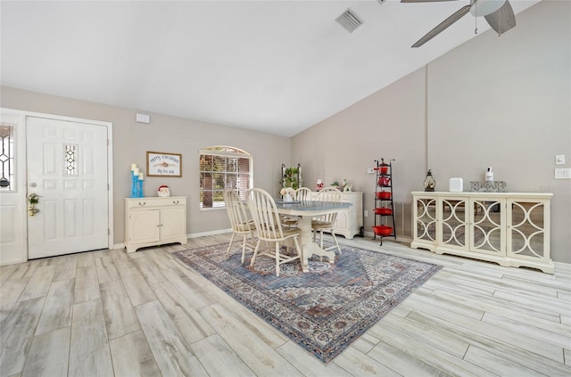 dining area with ceiling fan, lofted ceiling, and light wood-type flooring