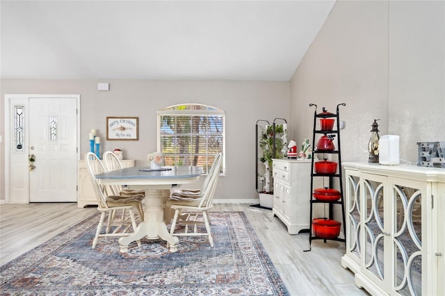 dining room featuring vaulted ceiling and light wood-type flooring