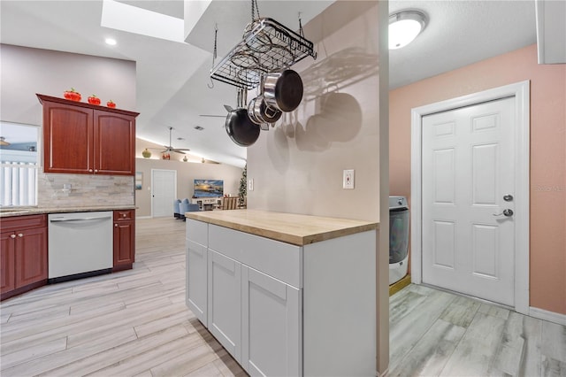 kitchen with lofted ceiling, wooden counters, white dishwasher, light hardwood / wood-style flooring, and washer / clothes dryer