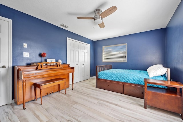 bedroom featuring ceiling fan, light wood-type flooring, and a closet