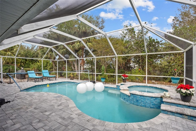 view of pool featuring an in ground hot tub, a patio, and glass enclosure