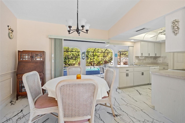 dining room featuring ceiling fan with notable chandelier, lofted ceiling, and sink