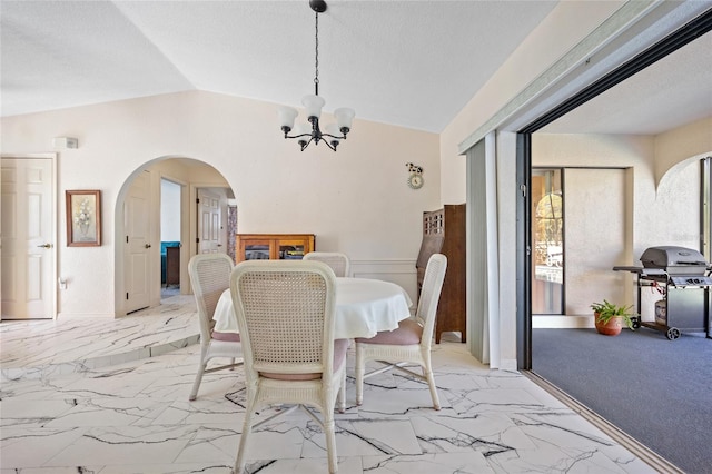 dining space with a notable chandelier and lofted ceiling