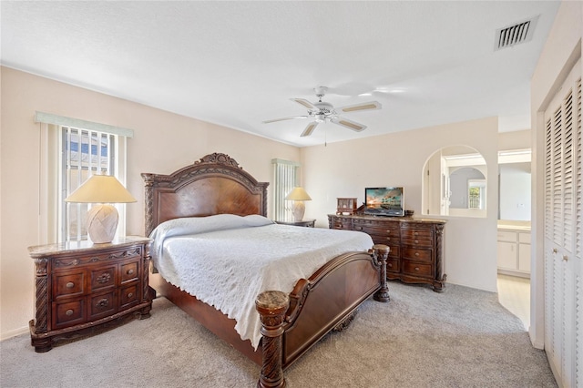 carpeted bedroom featuring ceiling fan, connected bathroom, and a closet