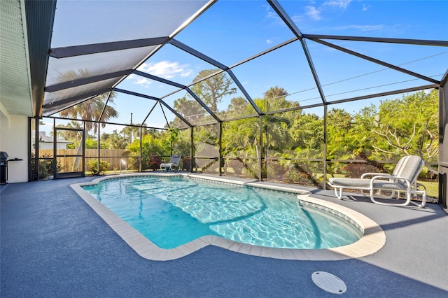 view of pool featuring glass enclosure and a patio area