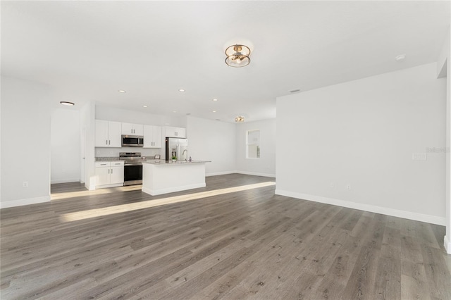 unfurnished living room with sink and hardwood / wood-style floors