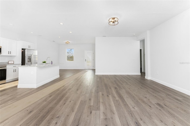 unfurnished living room with light wood-type flooring and sink