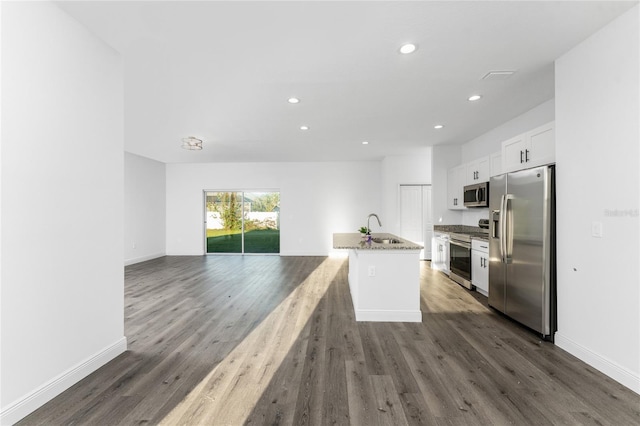 kitchen featuring sink, white cabinetry, light stone counters, a kitchen island with sink, and stainless steel appliances