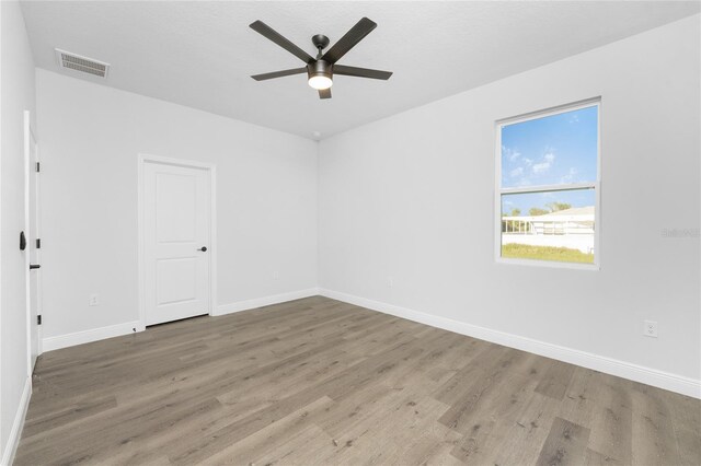 empty room with ceiling fan and wood-type flooring