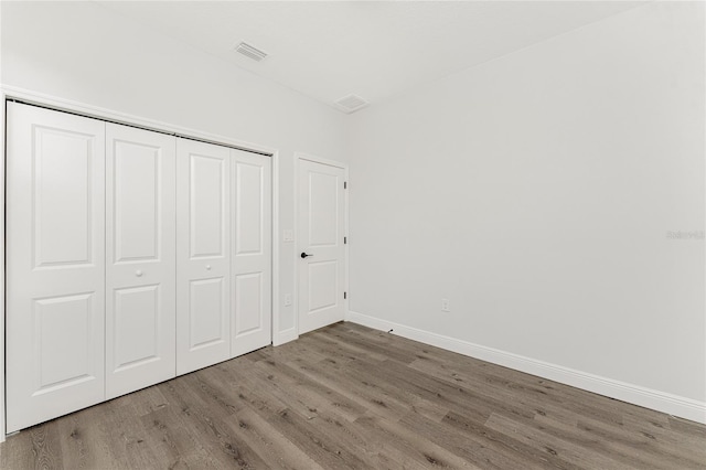 unfurnished bedroom with a closet and wood-type flooring