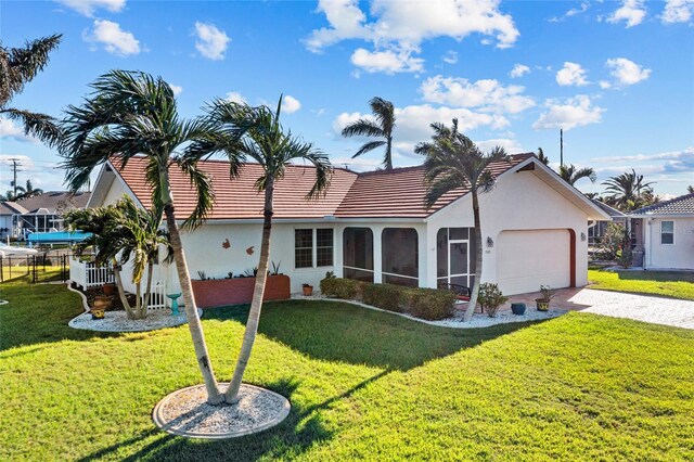 ranch-style house featuring a sunroom, a garage, and a front lawn