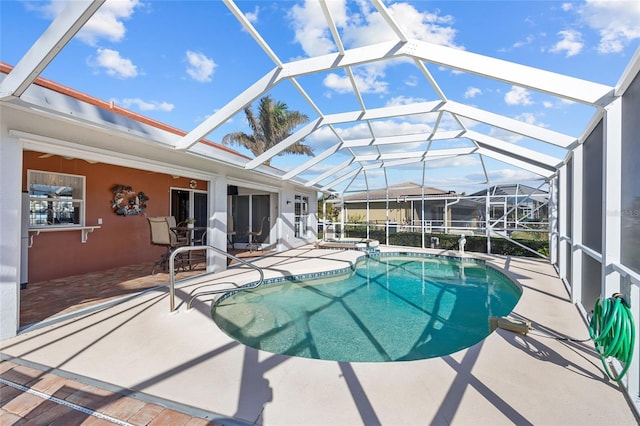 view of pool featuring glass enclosure and a patio