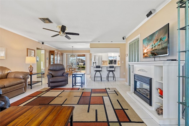 living room featuring crown molding, ceiling fan, and light tile patterned floors