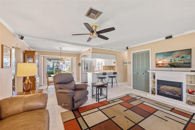 tiled living room with ceiling fan and crown molding