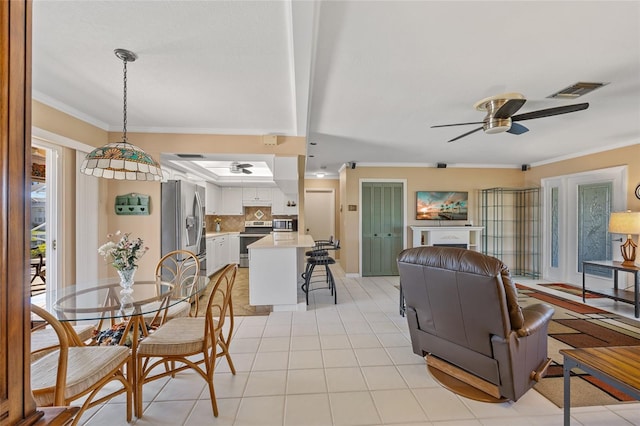 dining room featuring beam ceiling, ceiling fan, light tile patterned flooring, and ornamental molding