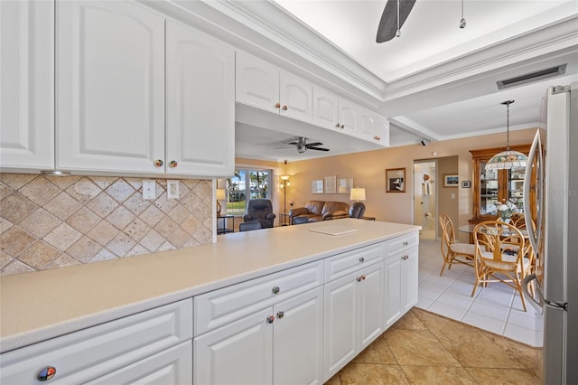 kitchen featuring white cabinets, crown molding, light tile patterned floors, tasteful backsplash, and stainless steel refrigerator