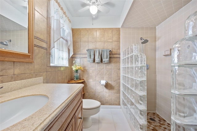 bathroom with tile patterned flooring, vanity, tile walls, and tiled shower