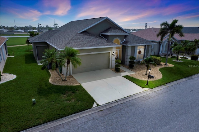 view of front of home featuring a garage and a yard