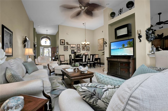 living room with a high ceiling and ceiling fan with notable chandelier