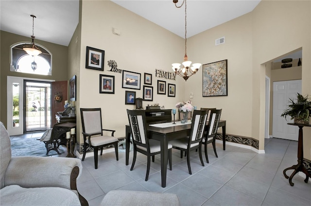 tiled dining room featuring high vaulted ceiling and a chandelier